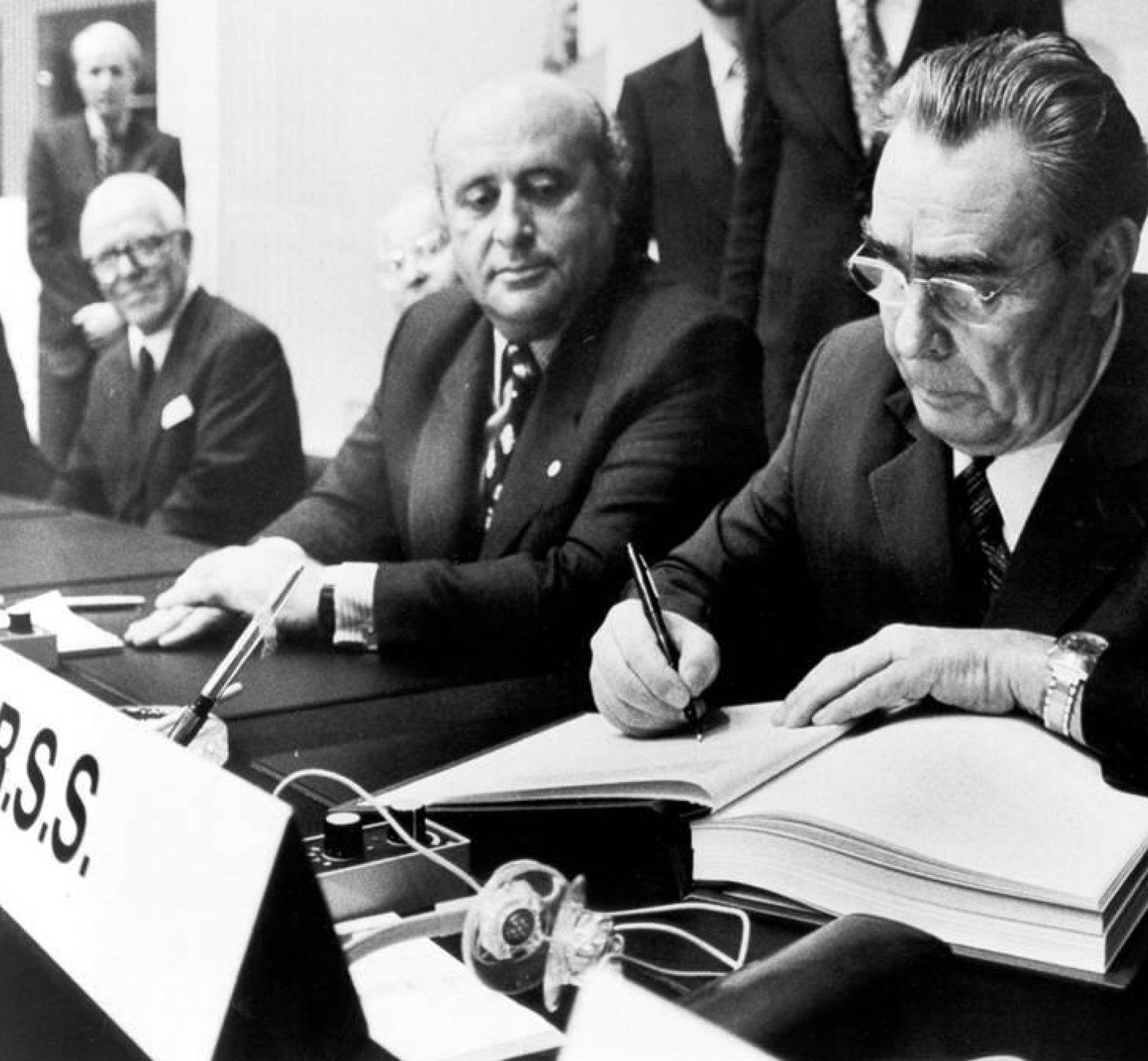 Leonid Brezhnev, General-Secretary of the Communist Party of the USSR, signing the Final Act, with Turkey's Prime Minister Suleyman Demirel to the left, Helsinki, 1 August 1975.