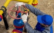 Image of a worker opening, closing the shut-off valves at the gas pumping station. Part of the photo is blurry.