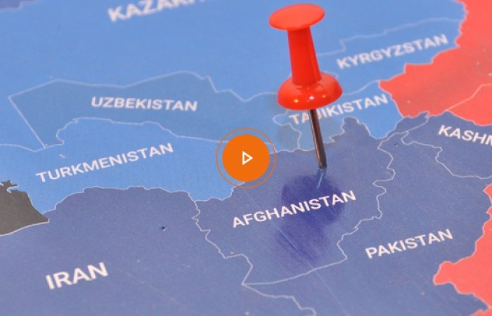 A map of South Asia with a pin in Afghanistan, an orange play button on top.
