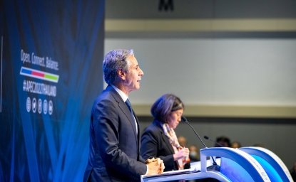 Secretary Blinken stands at a podium giving a speech.