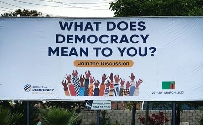 Billboard displaying "What does democracy mean to you"? for the 2023 Summit for Democracy