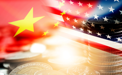 American and Chinese flags above a stack of coins