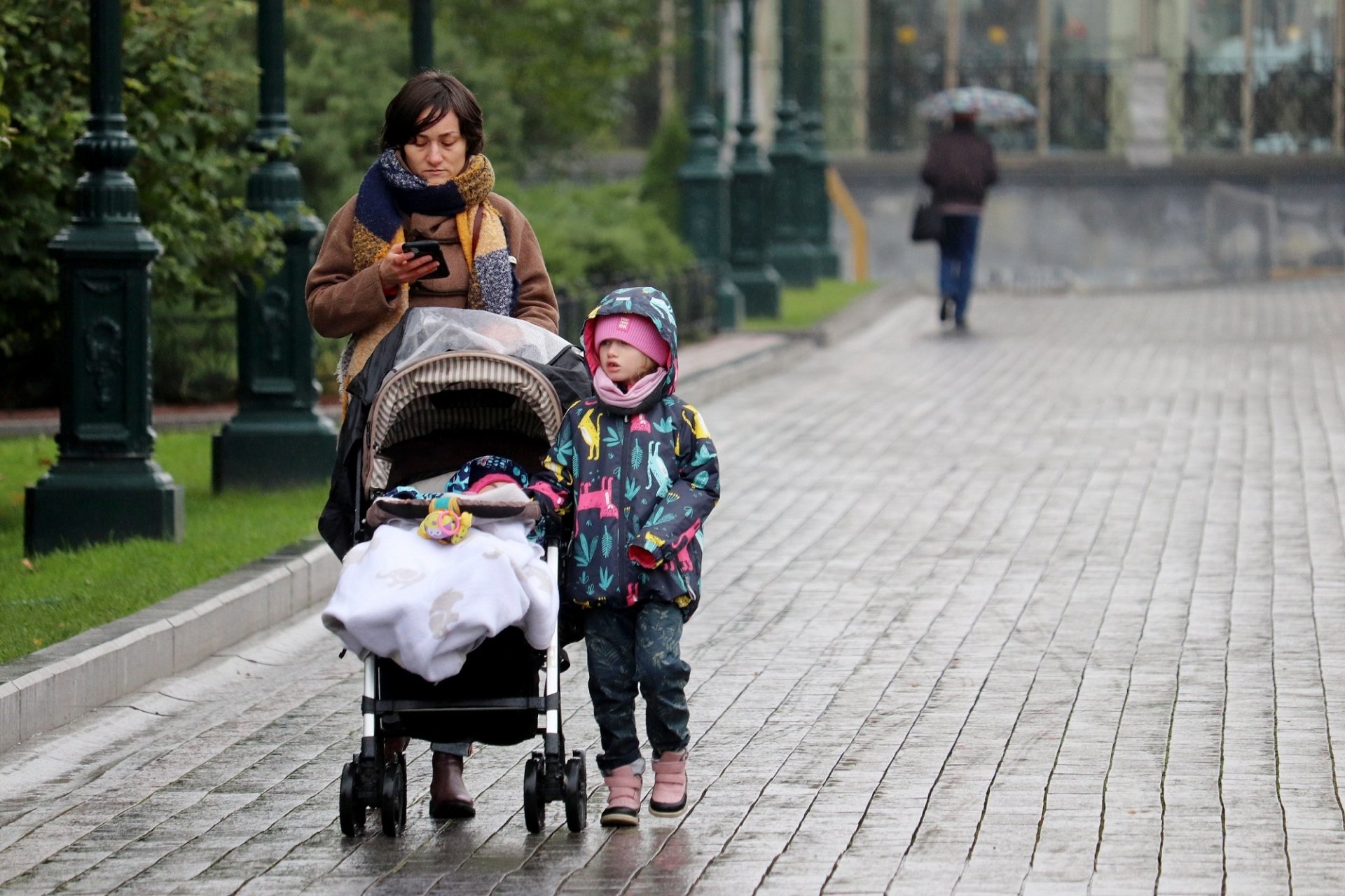 A mother and child walk down the street in Russia, October 2020