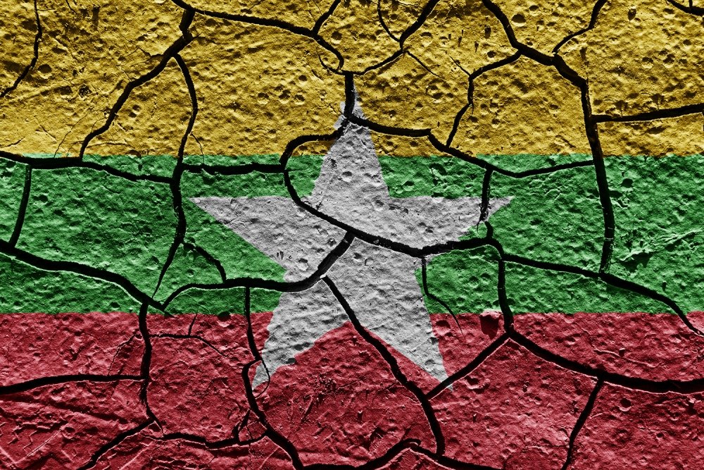 The flag of Myanmar painted on cracked pavement