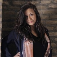 A photo of Fereshta Kazemi standing in front of a brick background