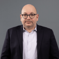 Jason Rezaian is pictured in front of a grey background.