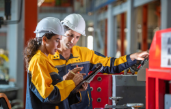 Two factory employees work together onsite