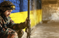 Soldier in front of Ukraine flag wall