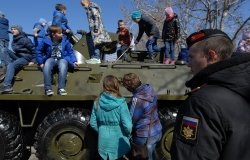 children play on a Russian armored car on the fifth anniversary of the annexation of Crimea