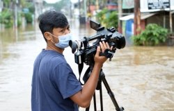 Television journalist covering the Bekasi flood in Bekasi, Indonesia